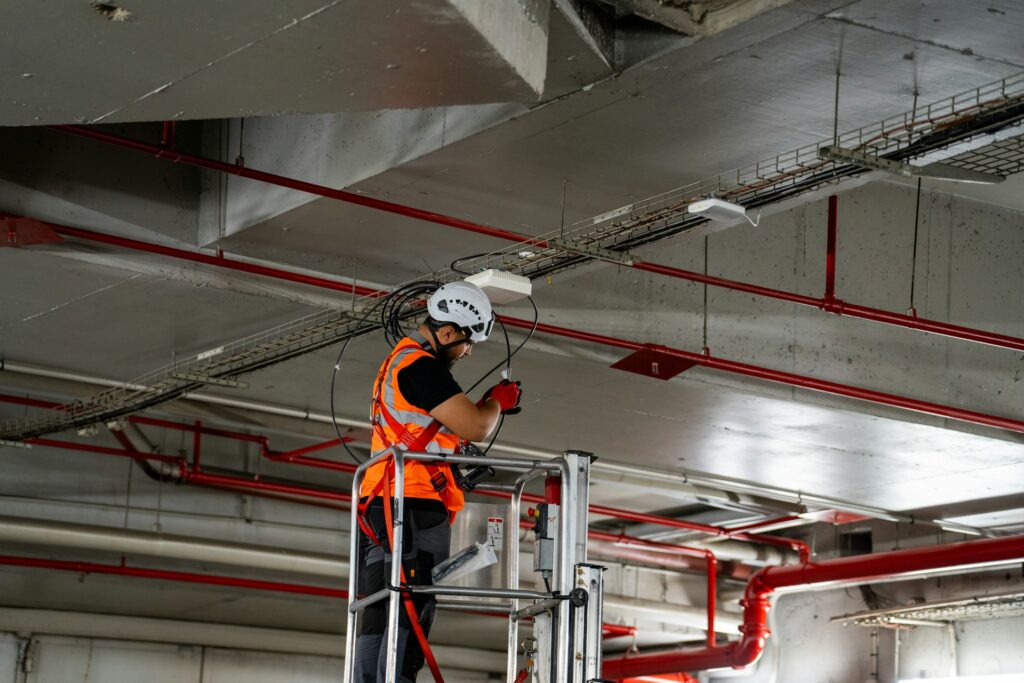 Worker installing fire protection systems in a commercial ceiling